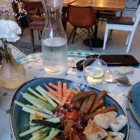 Seasonal hummus with pita bread, piriñaca (tomato, onion and green pepper salad), raw vegetables, crispy sweet potato and pan macho (traditional regional bread). at El Patio in Tarifa