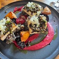 Grilled tofu with quinoa salad, roasted celeriac confit, pickled celery, beetroot hummus, chimichurri . at Bryggjan in Akureyri