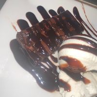 Vegan chocolate brownie with vegan vanilla ice cream and chocolate sauce.  at The White Swan Inn in Lowick