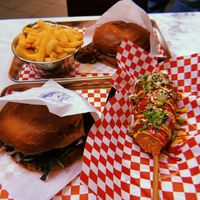 Double smash bacon burger, kitsune tofu burger with fries and a corn dog at Kitsune Burgers in Brussels