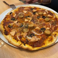 PIZZA ROMANA 
Pizza de masa casera con base de tomate frito, mozzarela, cebolla, rodajas de oliva negra, lonchas de Frankfurt, dados de mortadela y orégano. at A Flama in Zaragoza