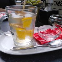 Gemberthee met de papiertjes van een vegan koekje erbij at De Broodplank in Gorinchem