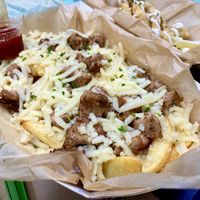 Salchipapas (french fries 🍟 sausage and vegan cheese) at Cala Vegana in Menorca