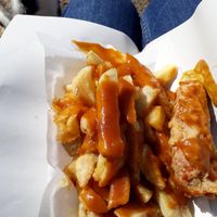 Battered sausage, chips and curry sauce. at Barnacles in Llandudno