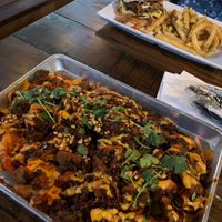 Viet-nachos (front) and blue cheese burger (back) as part of Houston Sauce Company night menu  at Mo' Brunch + Brews in Houston