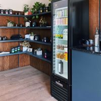 Interior merchandise shelves, takeaway fridge, condiment counter. at Elegy Coffee in Nashville