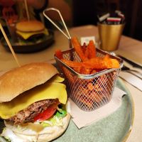 Vegan burger (soy, green peas burger), with vegan cheese, lettuce, tomato and avocado, served with sweet potato fries at La Rambla in Lloret De Mar