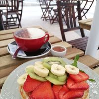 Pancake with fruits and maple syrup, almond cappuccino at O Croisant in Coimbra