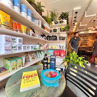 Seating area Roots 2 Rise, bookshelves, grocery "What the Fork are you eating?"My Tupperware with a R2R cookie, carrot muffin,Yeti cup with Chai tea, sugar & BLK lychee 7/24/2022 at Root 2 Rise in Pleasantville