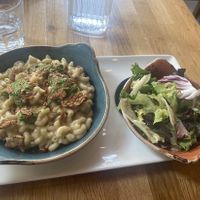 Vegan Mac & cheese with tempeh bacon, breadcrumbed onions and a spinach pesto sauce. Accompanied with a small salad   at Hendersons in Edinburgh