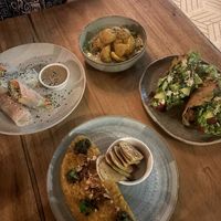 All vegan. Tofu summer rolls and peanut sauce. Crispy potatoes with a coconut cream cucumber sauce. Crispy tacos and risotto with these little bread dippers. at Gracias Vida in La Guajira