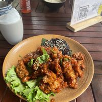 Orange chicken (requested black rice instead of white) and mashed potato with cashew gravy in the background   at Peanuts in Hoi An