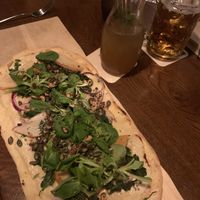 Pizza with spinach, sliced apple, onions, pumpkin seeds, basil and balsamic drizzle. And possibly a cashew cheese base.. A slightly sweet and savoury mix going on, very tasty   at Landwehr - Bräu am Turm in Rothenburg Ob Der Tauber