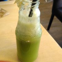 Green smoothie served innovatively in an open bottle, nicely decorated with physalis. at Max Pett in Munich