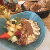 Lula-Frühstücksbowl: Soja-Joghurt, Mandelmus, Obst, hausgemachtes Granola und Brotkorb, der mit dem veganen oder vegetarischen Frühstück gebracht wird   at Lula in Berlin