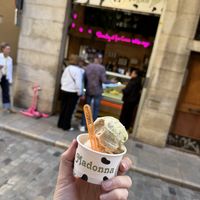 Pistachio ice cream on top, hidden snickers underneath. Outside the store   at Madonna Gelateri in Girona