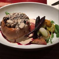 squash stuffed with a rice and berry mixture topped with cashew ";cheese"; sauce and sitting on a red wine berry reduction. Roasted carrots, onion, golden and red beets, and tomatoes.  at Blue Sage Vegetarian Grille in Southampton