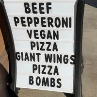 Rolling sign promoting vegan pizza at University Pizza Company in Riverside