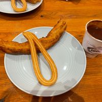 Churro (small) and porras (large) with labeled vegan chocolate. Menu is clearly labeled for vegan choices   at Chocolateria 1902 in Madrid