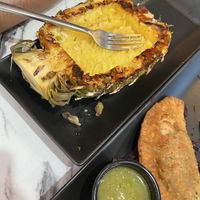 The pineapple that was left after my husband ate the pineapple fried rice. Also, one of the empanadas is in the photo.  at Gaia & Loki in Jersey City