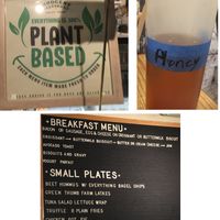 Confusing signs at Innocent Yesterday: one sign says "100% Plant Based," the other says "honey," the last doesn't specify that the food is vegetarian. at Innocent Yesterday in New York City