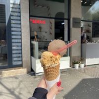 Salted caramel on top of peanut butter on vegan cone with vegan cookie wafer on top  at Fabrika in Tirana
