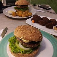 Hamburguesa 7 granos con papas criollas y salsa de maracuyá, falafel con hummus.  at Verdeo in Medellin