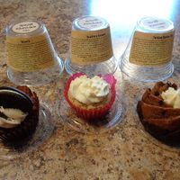 Velvet-O Crispy Cake (red velvet with 1/2 Oreo), Strawberry Balsamic Crispy Cake, Twisted Banana Chip Mini Bundt Cake (with a bite taken out of each, lol) and the containers they come in. at The Sweets Geek in Willoughby