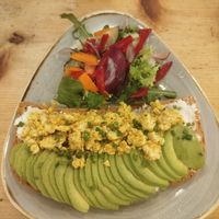 Tofu scramble with avocado and vegan cream cheese on toast at Café Floh in Barcelona