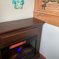 Ceramic fireplace with a wooden moose tchotchke that says, “I wasn’t born in the mountains, but I got here as fast as I could.” at Fired On The Mountain Cafe in Lincoln