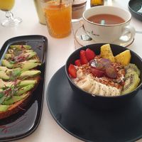 Avocado toast, yoghurt with fruit and granola, orange juice and tea - vegan menu option at Break Sé in Lisbon