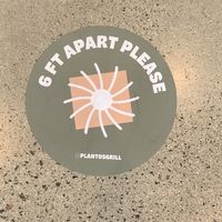 Social distancing stickers on the ground inside restaurant  at Plantos in Riverside