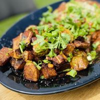 Huevo Ranchero: crispy corn tortilla, beans, fried vegan “egg”, poblano red sauce and guacamole.  Served with crispy paprika potatoes. Delicious✨ at Julia's Vegetarian Restaurant in Pacific Grove