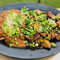 Huevo Ranchero: crispy corn tortilla, beans, fried vegan “egg”, poblano red sauce and guacamole.  Served with crispy paprika potatoes. Delicious✨ at Julia's Vegetarian Restaurant in Pacific Grove