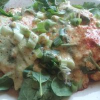 The Renedict, made vegan. Grilled ciabatta roll cut in two topped with fresh spinach, tofu scramble, slices of house tofu bacon, vegan Hollandaise and scallions.  at Bouldin Creek Cafe in Austin