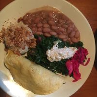 Veggie blend taco w/ guac., pinto beans, rice topped with crushed almonds, blanched greens and pickled veggies at Casa de Luz in Austin