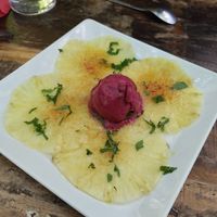 Caramelized Pineapple Carpaccio🍍served with Fresh Mint 🌿 and Black Currant Sorbet 🫐 at Le Cachotier in Carcassonne