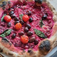Beetroot base pizza with vegan cheese, olives, tomato, balsamic at Schooners in St Agnes