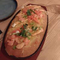 Corn bread in cast iron pan with vegan cheese on top at Source in York