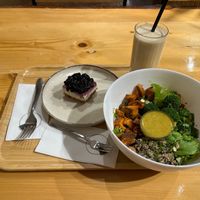Smoothie, bowl, and vegan dessert on a tray at Crust n Crumb in Pristina