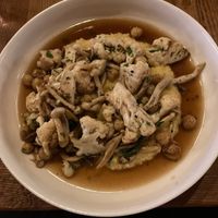 A dish titled "vegan" cauliflower, garbanzo beans, mushroom, polenta, burnt onion broth at Brazen Open Kitchen + Bar in Dubuque