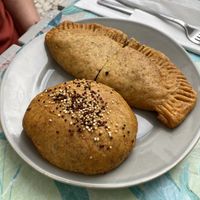Black, being mushroom empanada. Also, quinoa, olive, and vegan cheese roll.  at Pimpinelas Coffe Shop Vegetariano in Santa Cruz Madeira