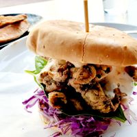 These are Breaded Oyster Mushrooms stacked on all sorts of veggie goodies like a Burger with a smashed potato herb garlic cake & side of Roasted Sweet Potato Wedges with an herbed dairy free dipping aioli sauce at Christopher's Kitchen in Palm Beach Gardens