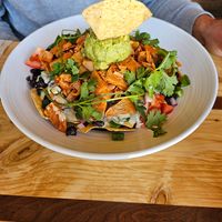 Filling nachos with tasty cheese sauce at Rooted: Eat More Plants in Medford