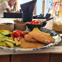 Pancakes with marinaded Tomatos, cucumber , capsicum, vegan cheese, peanutbutter , strawberries Jam and a vegan joghurt with fruits at Giorgos in Rhodes