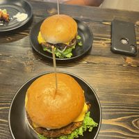Identical homemade burgers with different toppings  at PlantPub in Cambridge