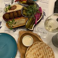 Tahini dip with the bread, mezzes falafel, humus, baba ganoush…   at Hamsa in Krakow