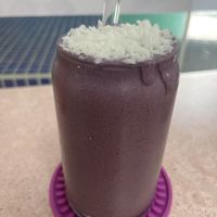 Purple Haze smoothie with freshly grated coconut. Glass straw too!  at Crisp in Roatan