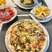 Vegan pizza, vegan lasagna tomato and onion salad and chips  at Louro & Salsa in Albufeira