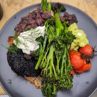 Vegan breakfast plate including broccoli, guacamole, vegan stracciatella, black bean mole, flat mushroom and roast tomato at Common Ground in North London